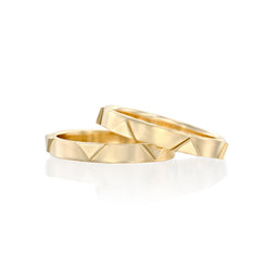 A pair of solid 14k gold rings featuring a geometric design with recessed triangular details. The combined band width is approximately 6mm, showcasing a modern and bold aesthetic.