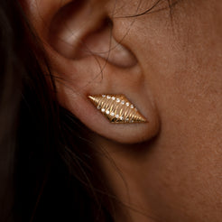 Close-up of a sleek, textured Starship crawler earring in solid 14k gold, shaped like a pointed diamond and set with sparkling 0.8mm round lab-grown white diamonds. A bold and radiant design that inspires movement and elegance. 