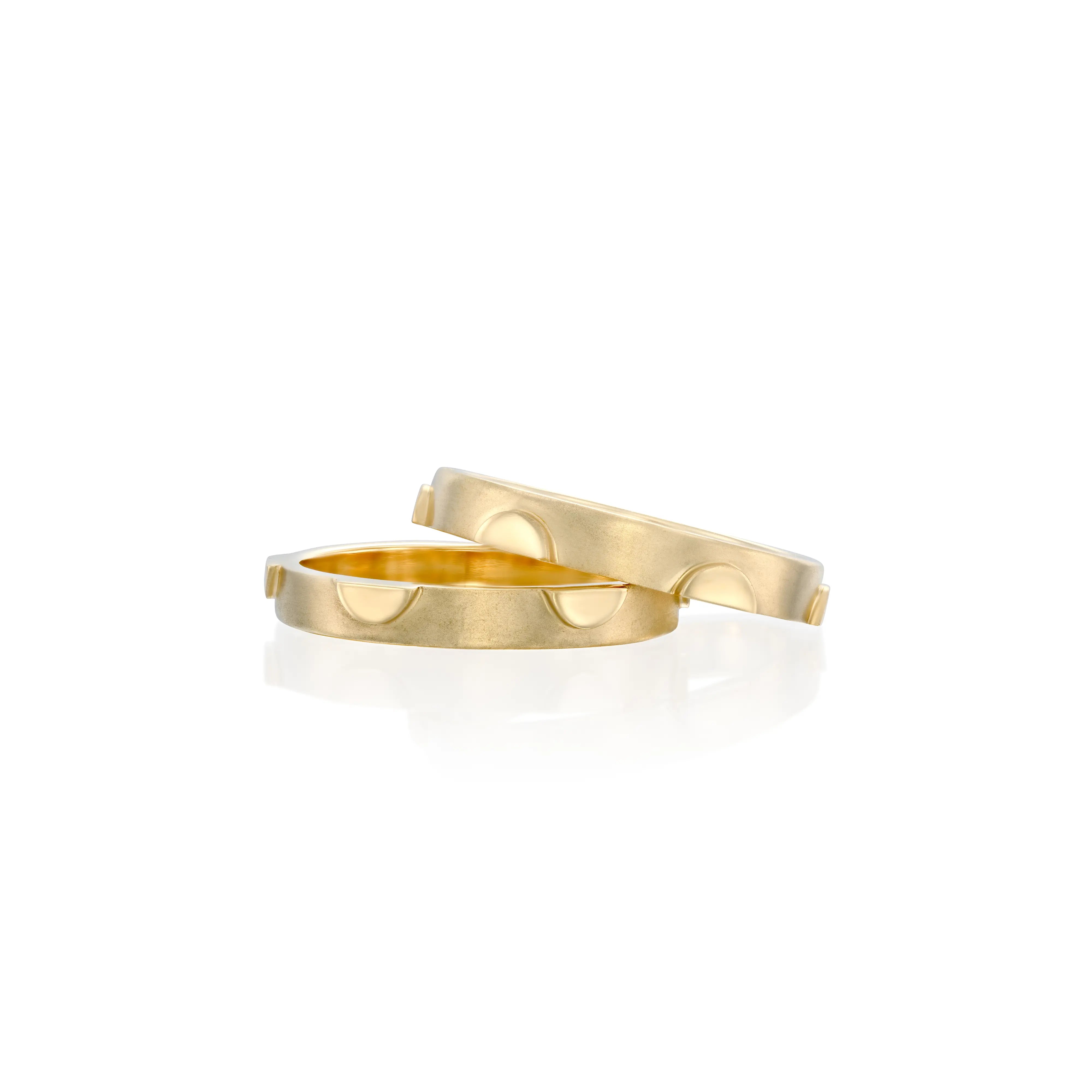 A pair of solid 14k gold Rotation Rings featuring a sleek and minimalist half moon design with subtle recessed circular details. The combined band width is approximately 6mm, showcasing a modern and refined aesthetic. 