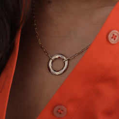 the Lifebuoy Necklace, featuring a solid 14k gold circular pendant with intricate engraved details on a paperclip link chain.